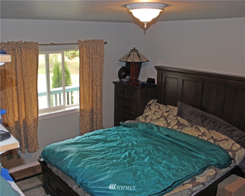 17238 Weaver Lane Southwest Rochester, WA 98579 - Photo 16 of 24 a bed sitting in a bedroom next to a window