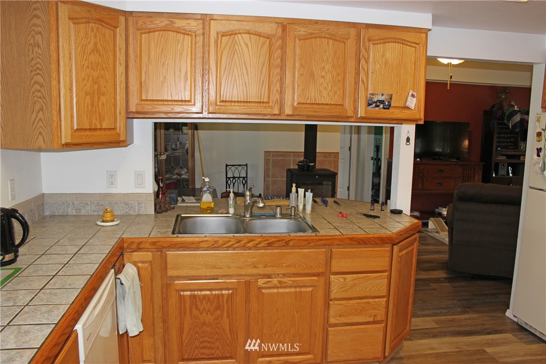 17238 Weaver Lane Southwest Rochester, WA 98579 - Photo 18 of 24 a kitchen with stainless steel appliances granite countertop a sink and cabinets