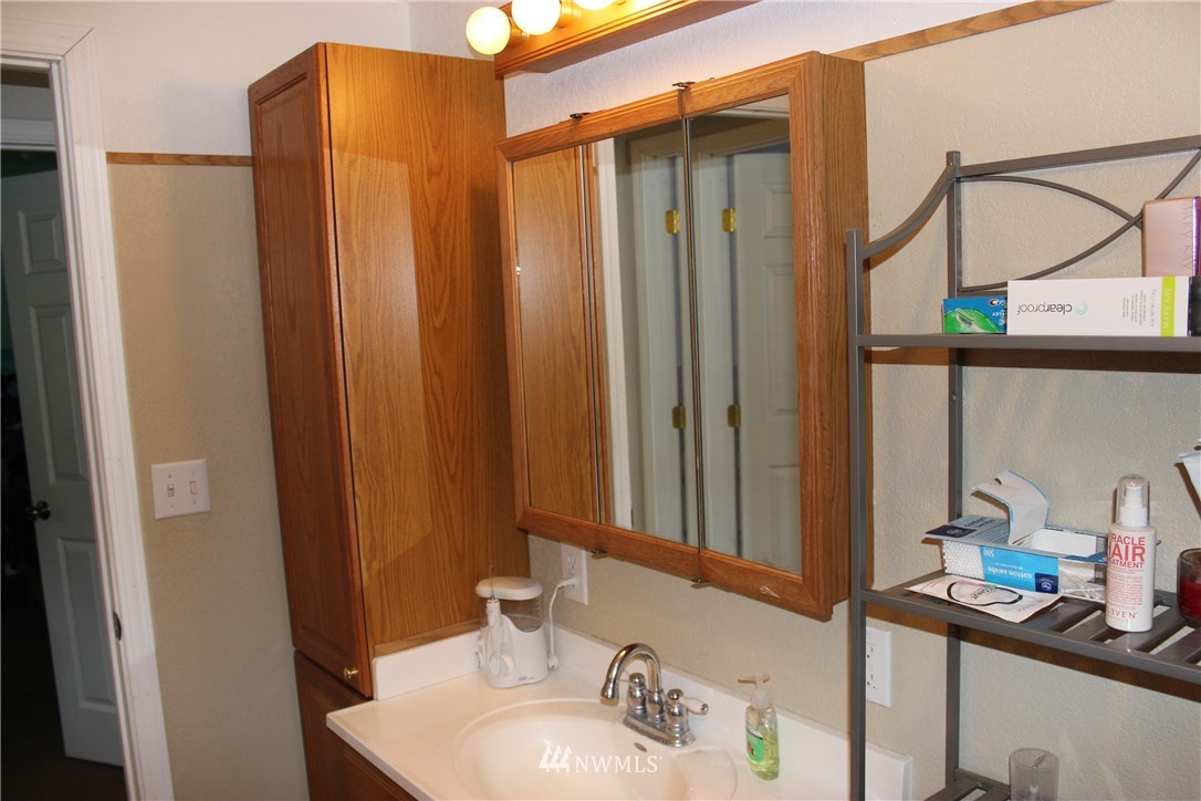 17238 Weaver Lane Southwest Rochester, WA 98579 - Photo 20 of 24 a bathroom with a sink a mirror and a shower curtain