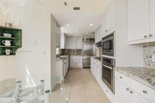 a kitchen with white cabinets and stainless steel appliances