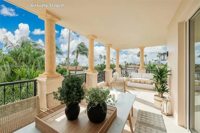 a view of a balcony with chairs and a potted plant