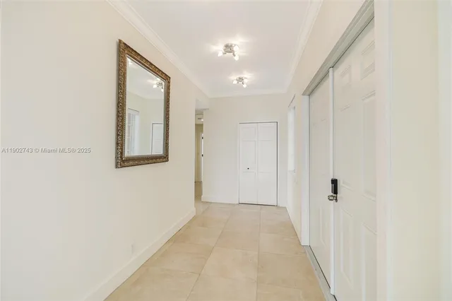 a view of a hallway with wooden floor and a bathroom