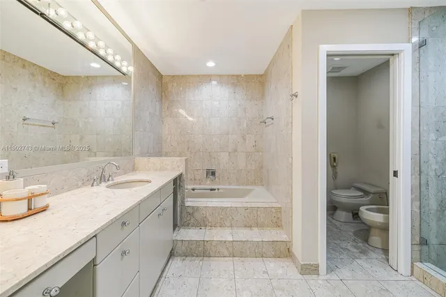 a bathroom with a granite countertop sink a toilet and shower