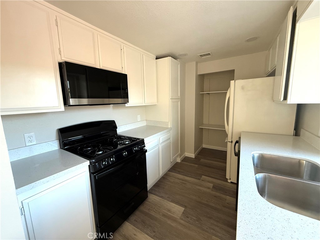 3445 Sparrow Circle Riverside, CA 92503 - Photo 6 of 41 a kitchen with a sink stove and microwave