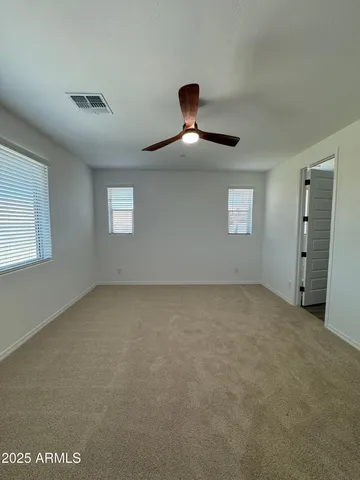 an empty room with a ceiling fan and window