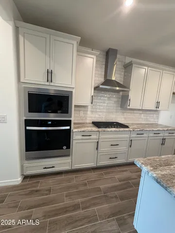 a kitchen with granite countertop a stove oven and cabinets