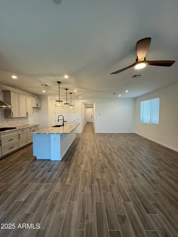 a large room with kitchen island a sink and wooden floor