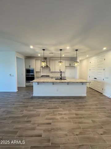 a large kitchen with kitchen island a sink stainless steel appliances and cabinets