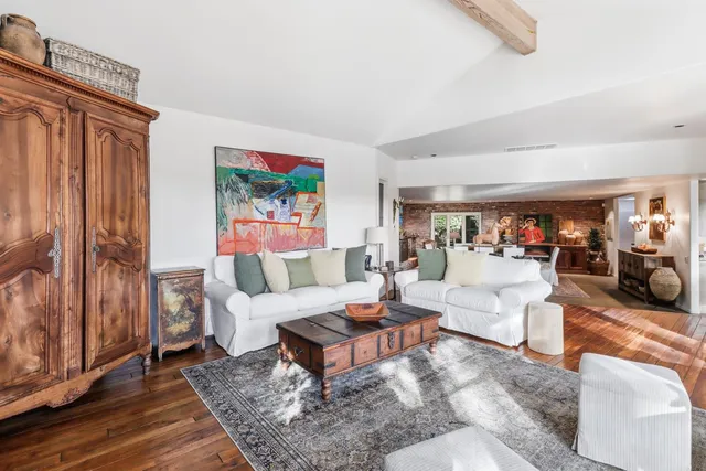 a spacious bedroom with a bed a couch and large window