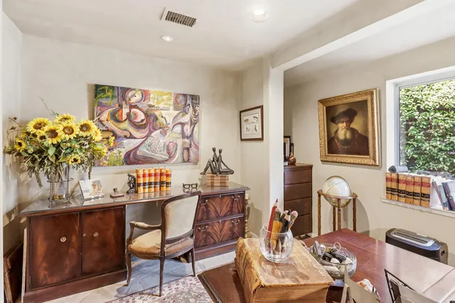 a front view of a building with a garden and outdoor seating