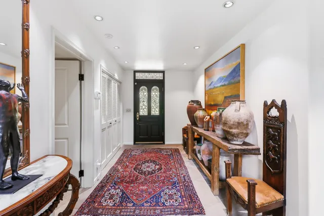a living room with furniture a rug and a painting on the wall