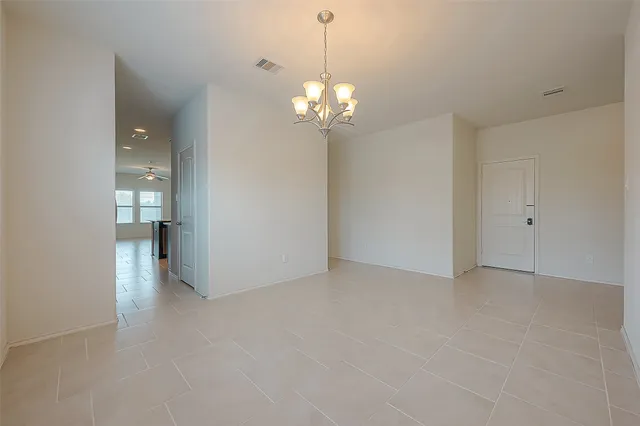 a view of an empty room with a chandelier