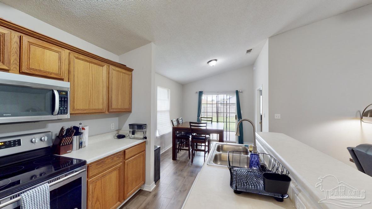 616 Reservation Avenue Pensacola, FL 32507 - Photo 11 of 29 a kitchen with a table chairs stove and cabinets