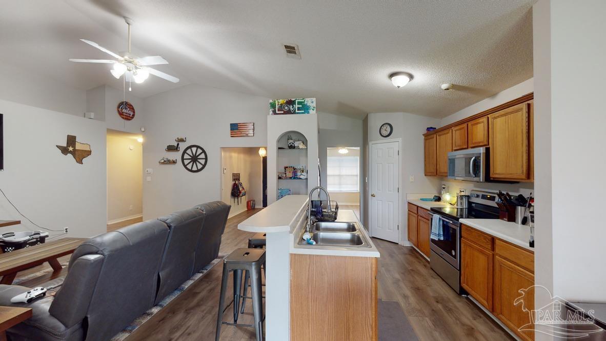 616 Reservation Avenue Pensacola, FL 32507 - Photo 12 of 29 a large living room with stainless steel appliances granite countertop furniture a flat screen tv and wooden floor