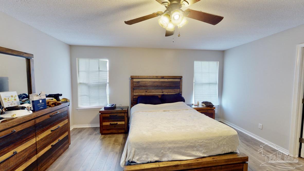 616 Reservation Avenue Pensacola, FL 32507 - Photo 16 of 29 a bedroom with a bed and wooden floor