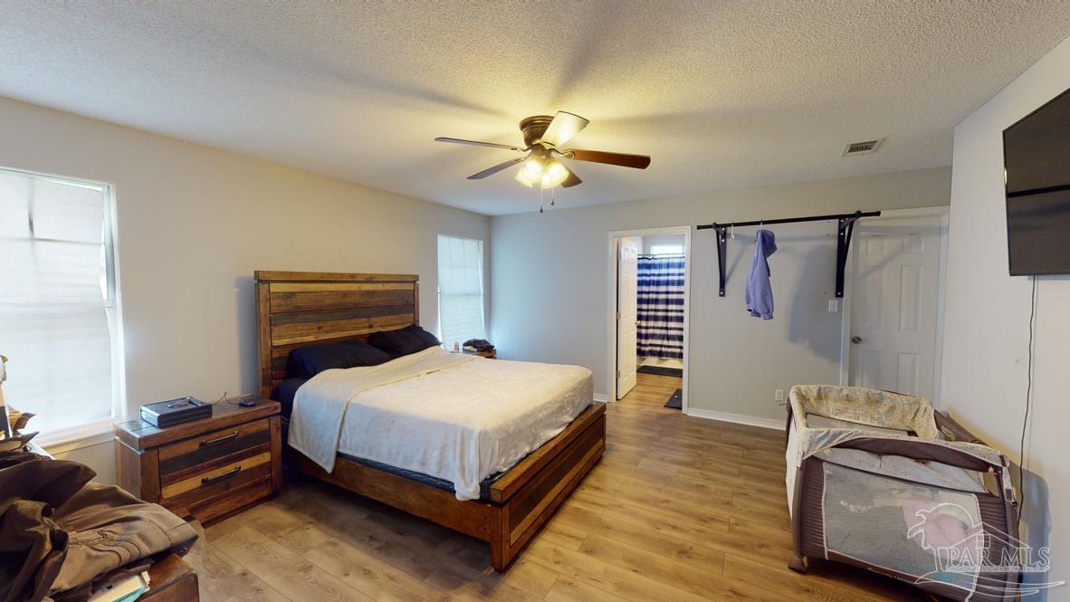 616 Reservation Avenue Pensacola, FL 32507 - Photo 18 of 29 a bedroom with a bed and a chandelier