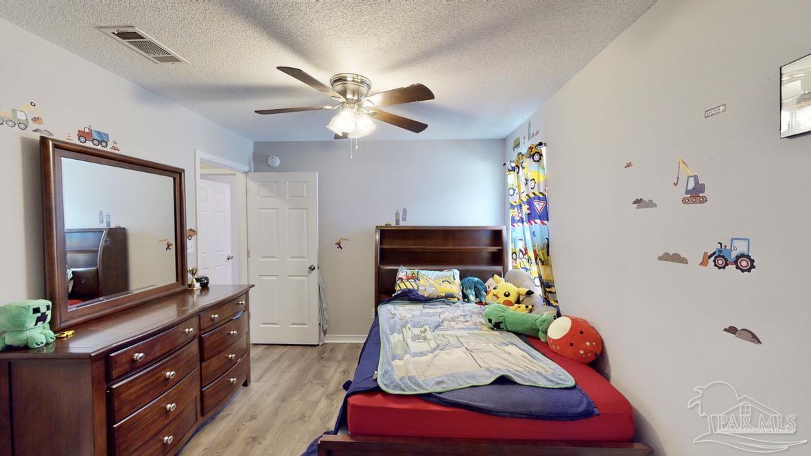 616 Reservation Avenue Pensacola, FL 32507 - Photo 23 of 29 a bedroom with a bed and a flat tv screen on the dresser