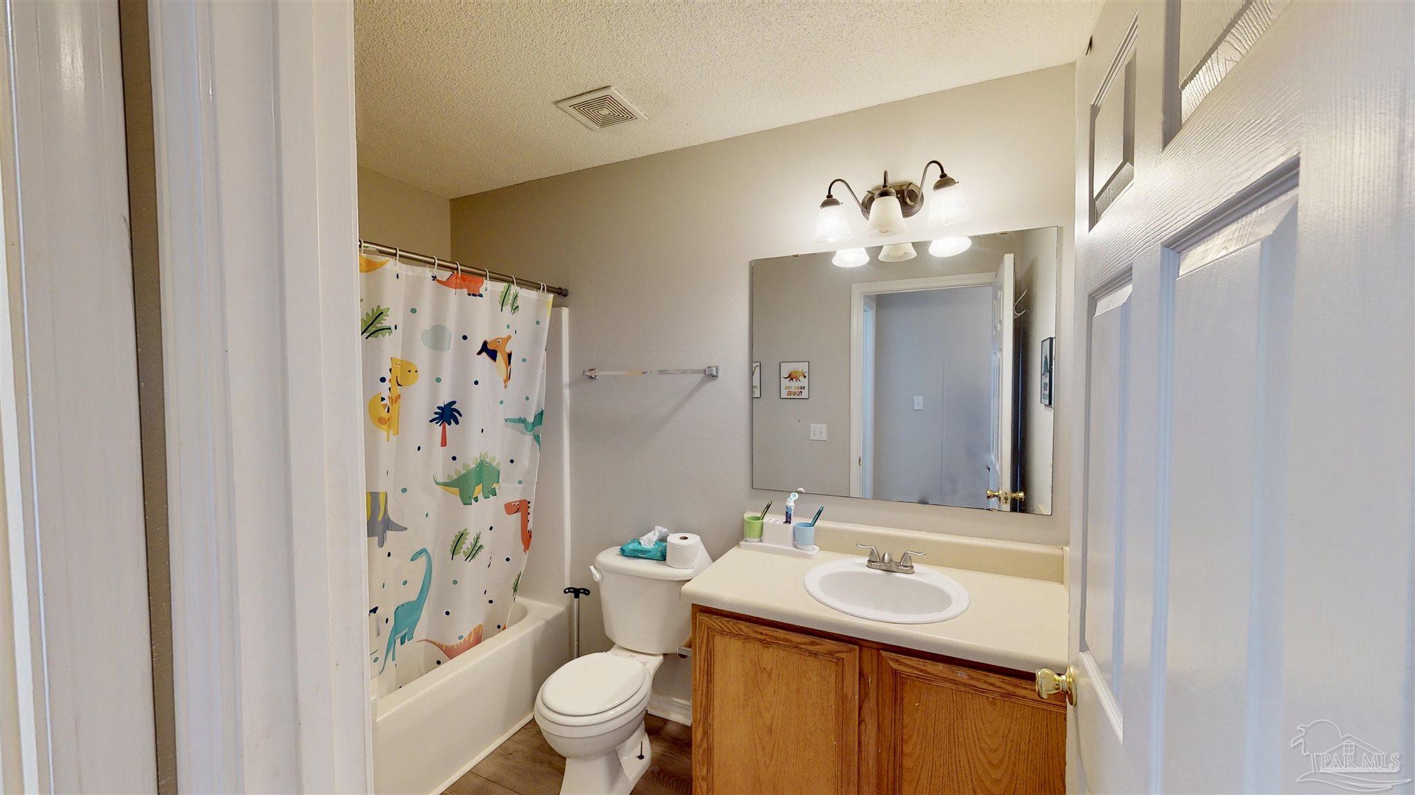 616 Reservation Avenue Pensacola, FL 32507 - Photo 24 of 29 a bathroom with a sink a toilet a shower curtain and a mirror