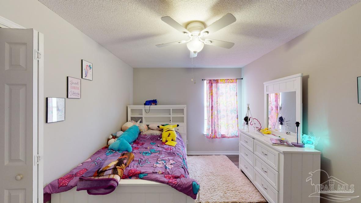 616 Reservation Avenue Pensacola, FL 32507 - Photo 27 of 29 a bedroom with a bed and a chandelier