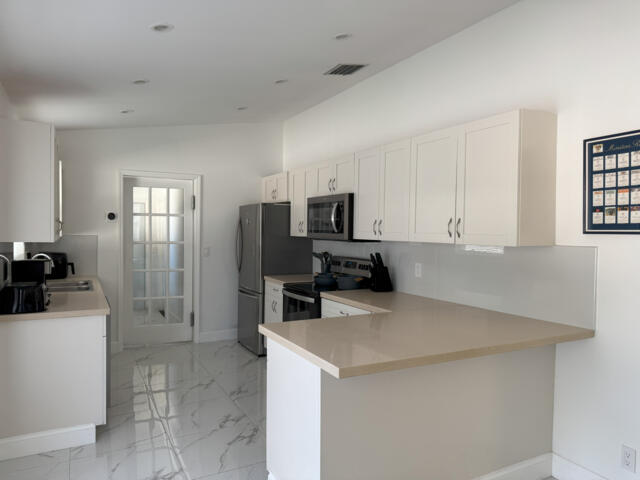 9420 Nickels Boulevard Boynton Beach, FL 33436 - Photo 15 of 57 a kitchen with stainless steel appliances a refrigerator sink and microwave