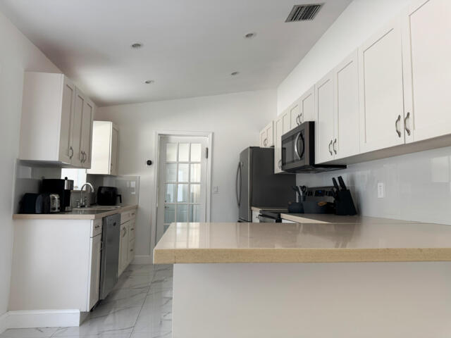 9420 Nickels Boulevard Boynton Beach, FL 33436 - Photo 16 of 57 a kitchen with a sink a stove and cabinets
