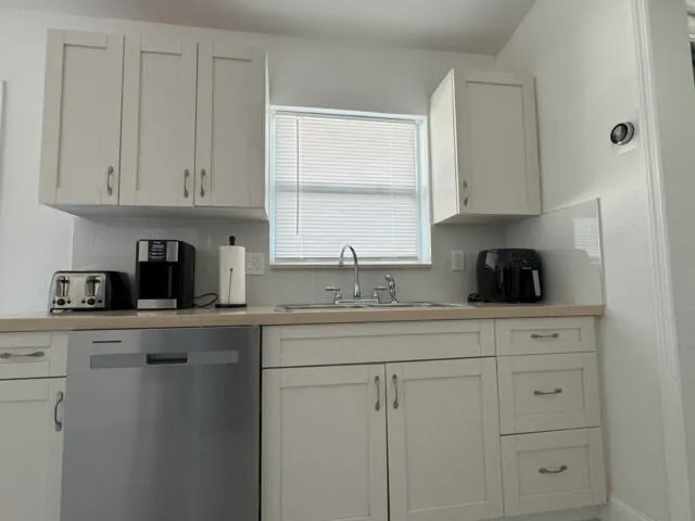 a kitchen with a sink a refrigerator and cabinets