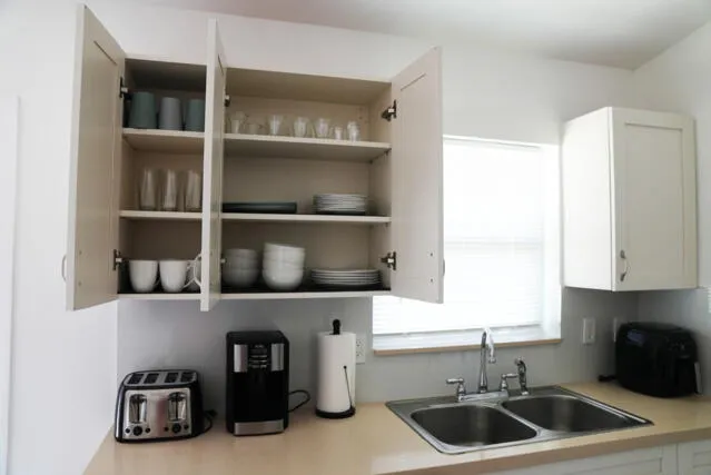 a kitchen with cabinets appliances a sink and a window