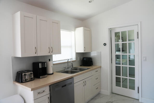9420 Nickels Boulevard Boynton Beach, FL 33436 - Photo 22 of 57 a kitchen with cabinets appliances a sink and a window