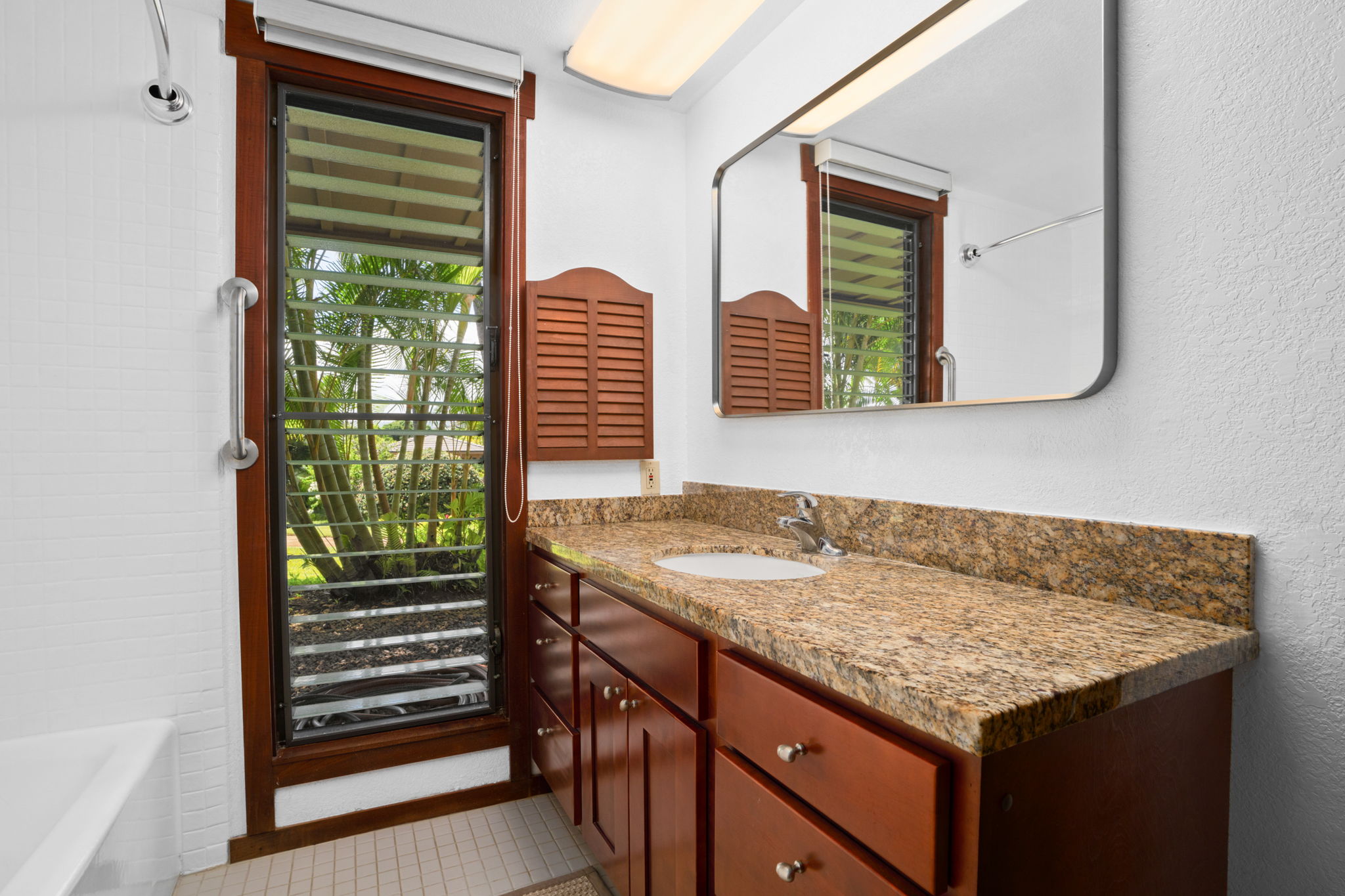 1870 Hoone Road, Unit 511 Koloa, HI 96756 - Photo 21 of 26 a bathroom with a granite countertop sink and mirror