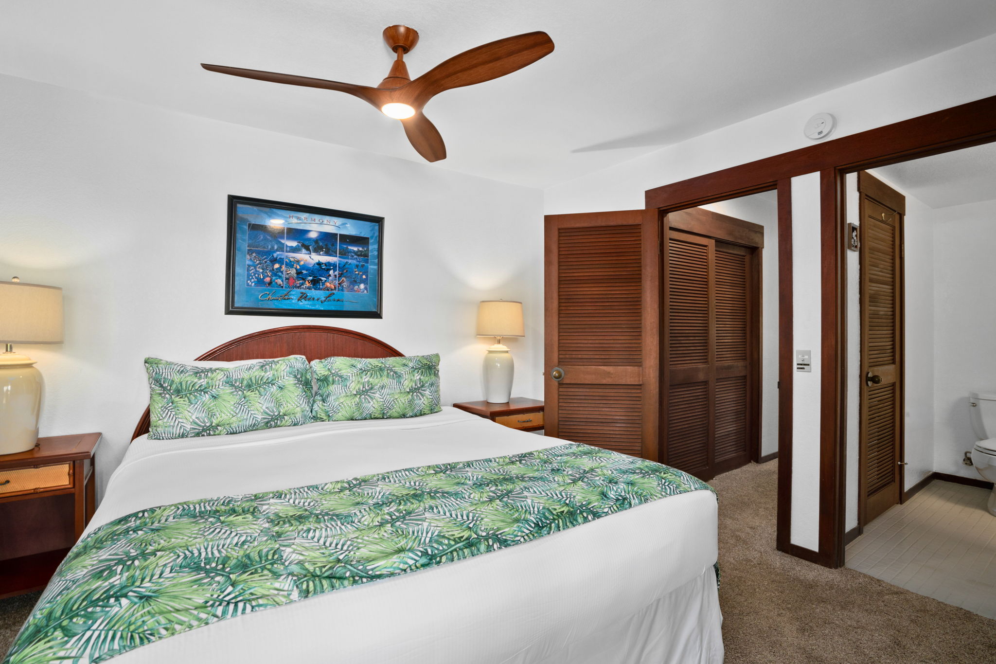 1870 Hoone Road, Unit 511 Koloa, HI 96756 - Photo 22 of 26 a bedroom with a large bed and a chandelier
