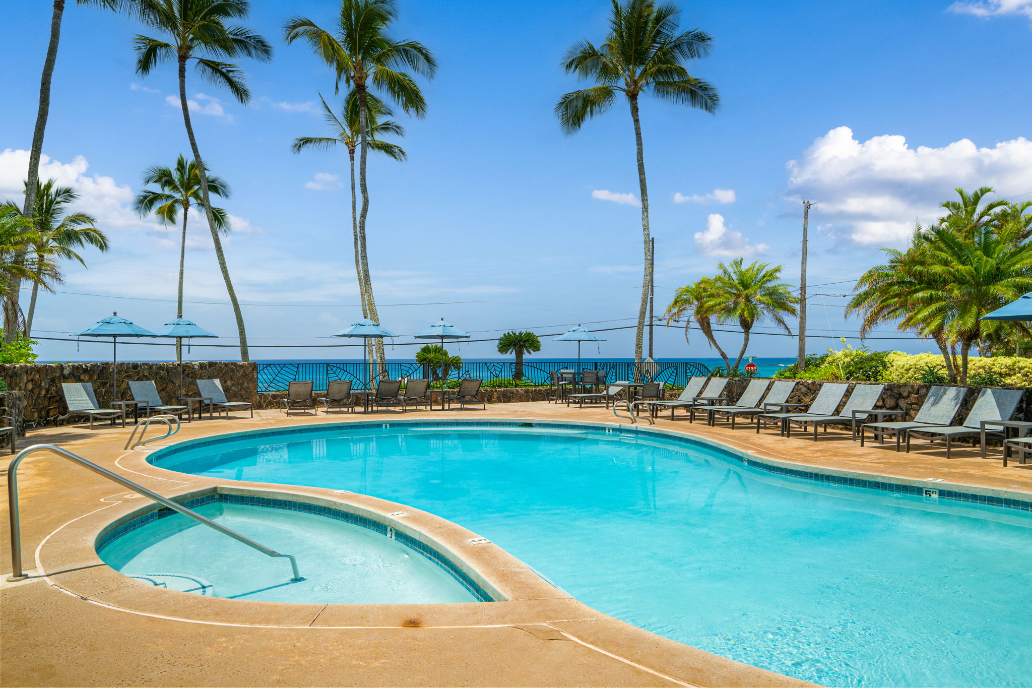 1870 Hoone Road, Unit 511 Koloa, HI 96756 - Photo 25 of 26 a view of a swimming pool with a table and chairs