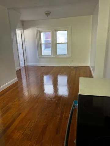 a view of a hallway with wooden floor and a cabinet
