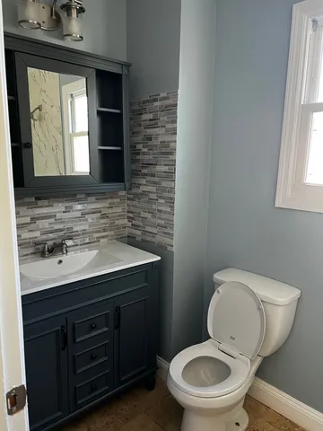a bathroom with a toilet sink and mirror