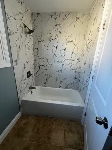 a bathroom with a bathtub and shower