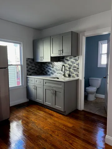 a kitchen with stainless steel appliances a sink cabinets and wooden floor