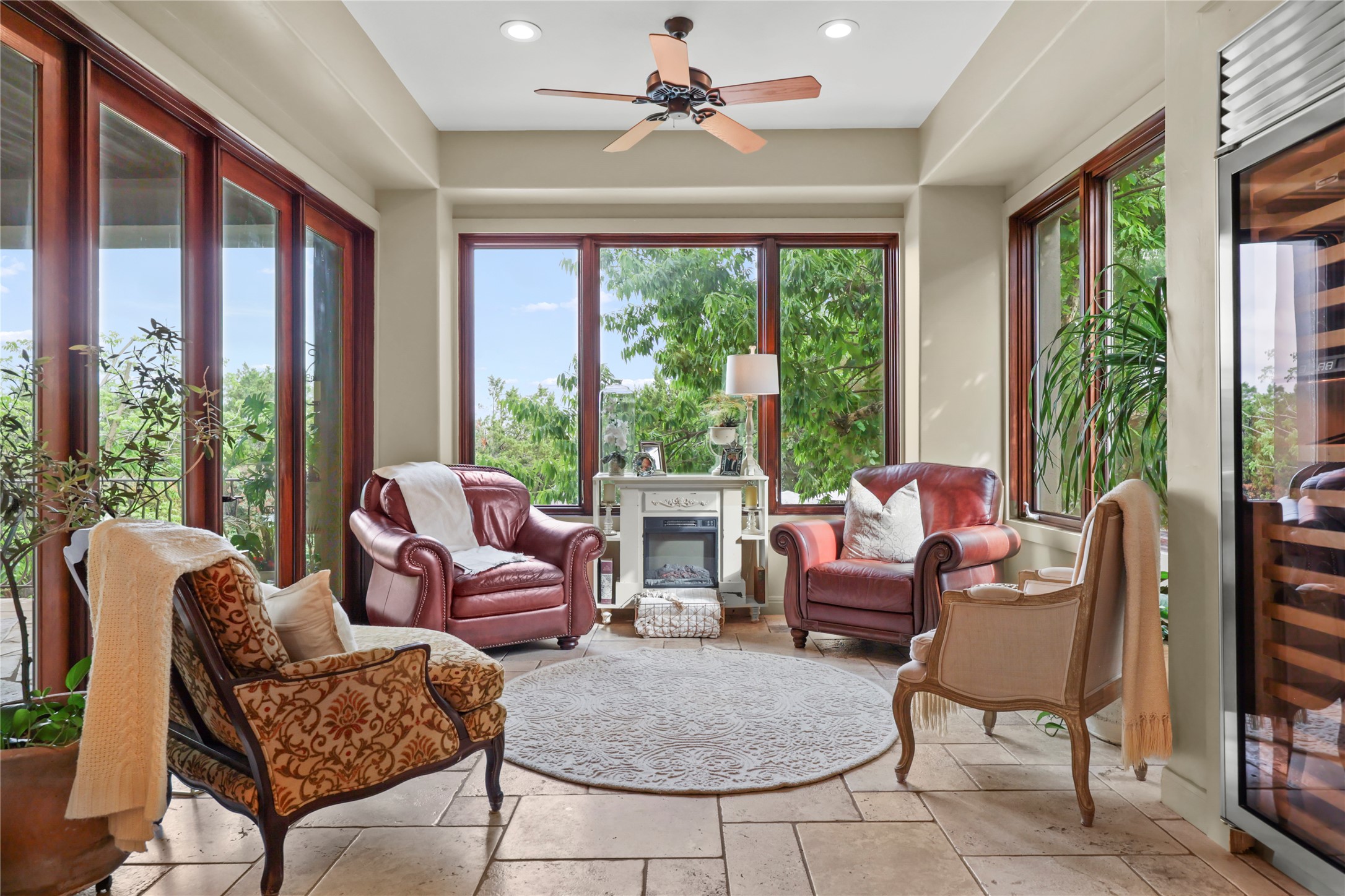 17501 Navigation Lane Lago Vista, TX 78645 - Photo 16 of 40 Sunroom featuring expansive windows providing natural light, a ceiling fan, and tiled flooring