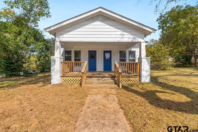 a view of a house with backyard and a tree