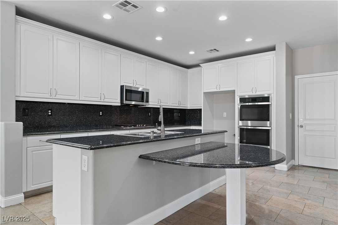 312 Pocono Ranch Avenue North Las Vegas, NV 89031 - Photo 4 of 34 Kitchen with visible vents, backsplash, appliances with stainless steel finishes, and recessed lighting