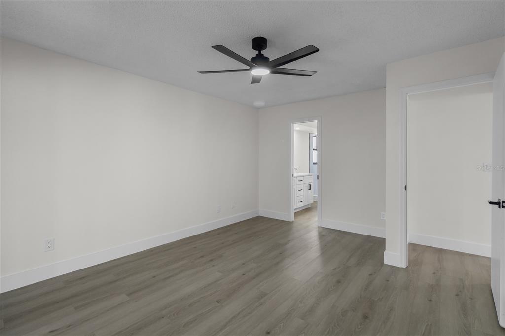 1888 Springbush Lane Clearwater, FL 33763 - Photo 13 of 31 an empty room with wooden floor and a ceiling fan
