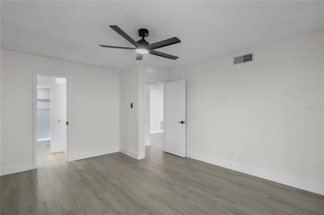 a view of a big room with wooden floor and windows