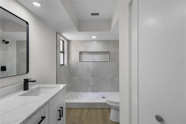 a bathroom with a sink a toilet and shower