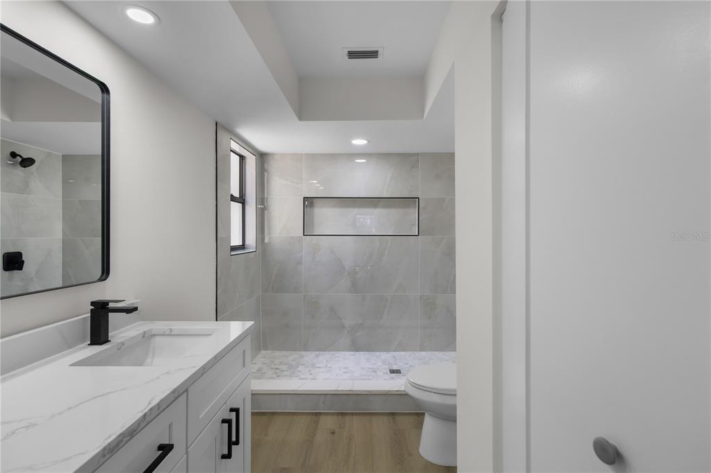 1888 Springbush Lane Clearwater, FL 33763 - Photo 15 of 31 a bathroom with a sink a toilet and shower