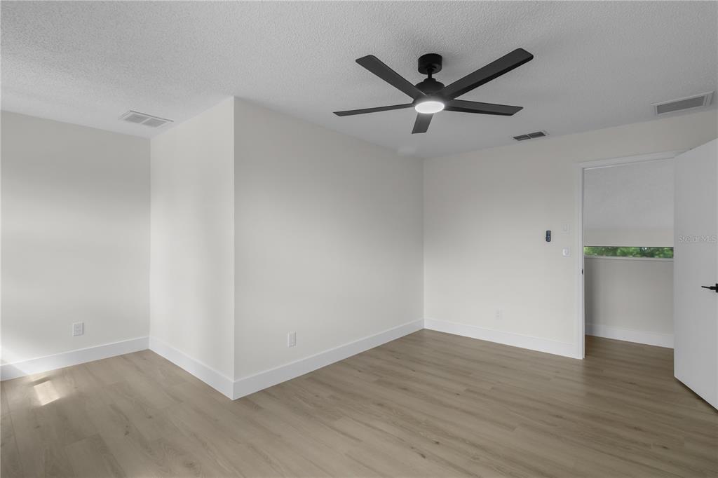1888 Springbush Lane Clearwater, FL 33763 - Photo 19 of 31 an empty room with wooden floor and a ceiling fan