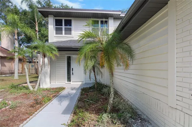 a view of a house with a yard and potted plants
