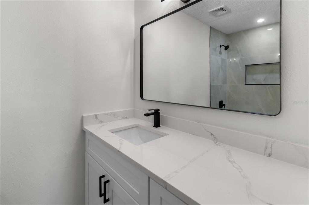 1888 Springbush Lane Clearwater, FL 33763 - Photo 23 of 31 a bathroom with a sink and a mirror
