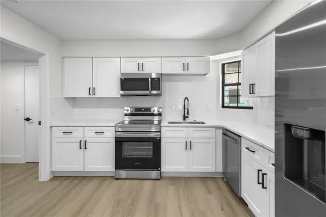 a kitchen with stainless steel appliances a stove a sink and a microwave