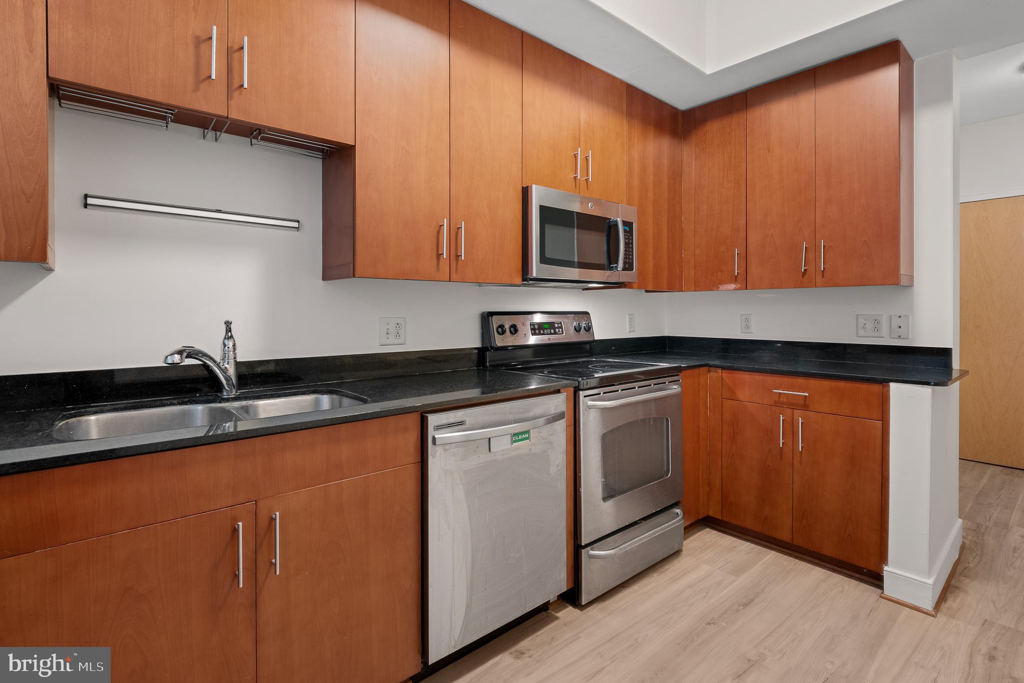 910 M Street Northwest, Unit 126 Washington, DC 20001 - Photo 13 of 54 a kitchen with stainless steel appliances granite countertop a sink a stove and microwave