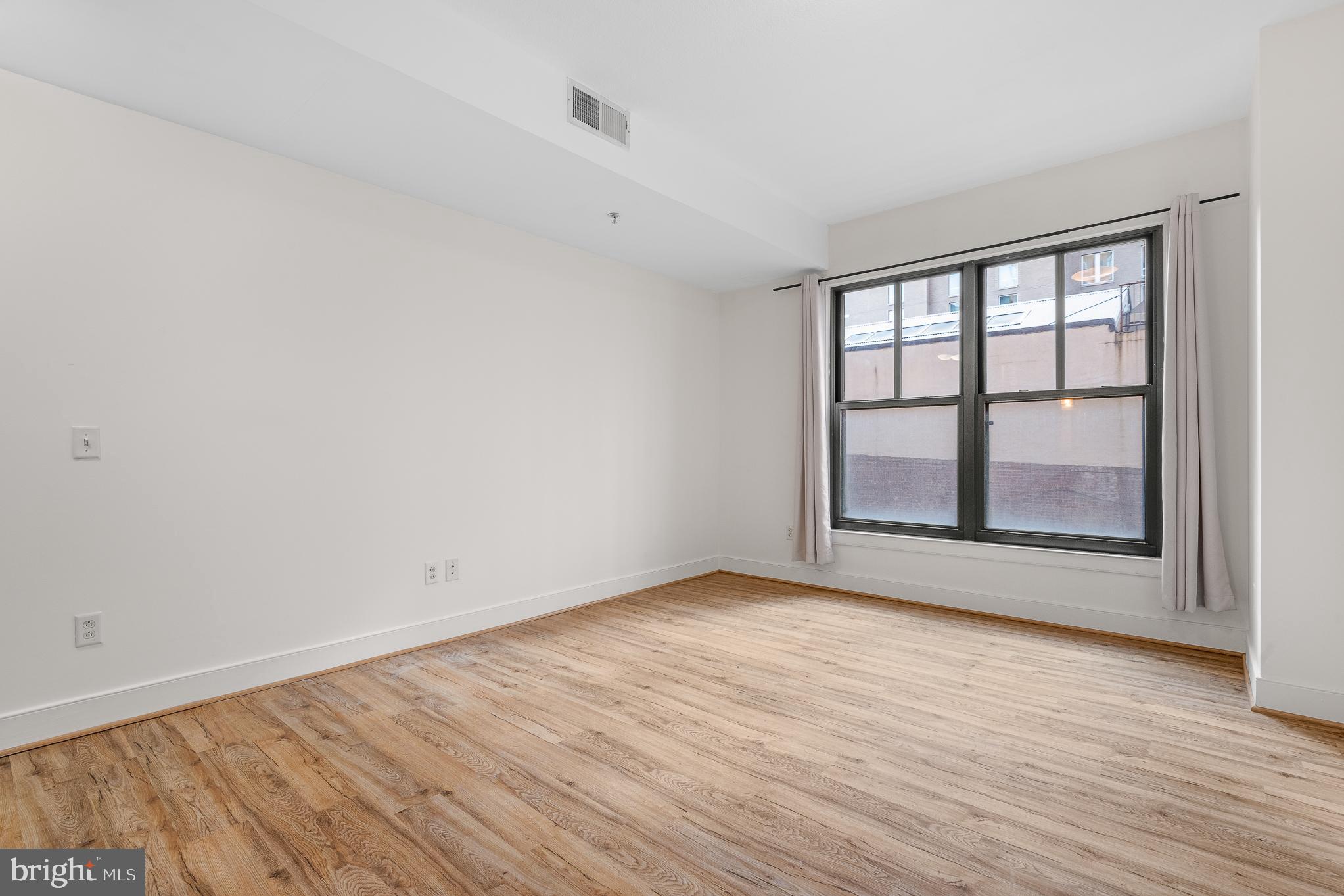 910 M Street Northwest, Unit 126 Washington, DC 20001 - Photo 21 of 54 wooden floor in an empty room with a window