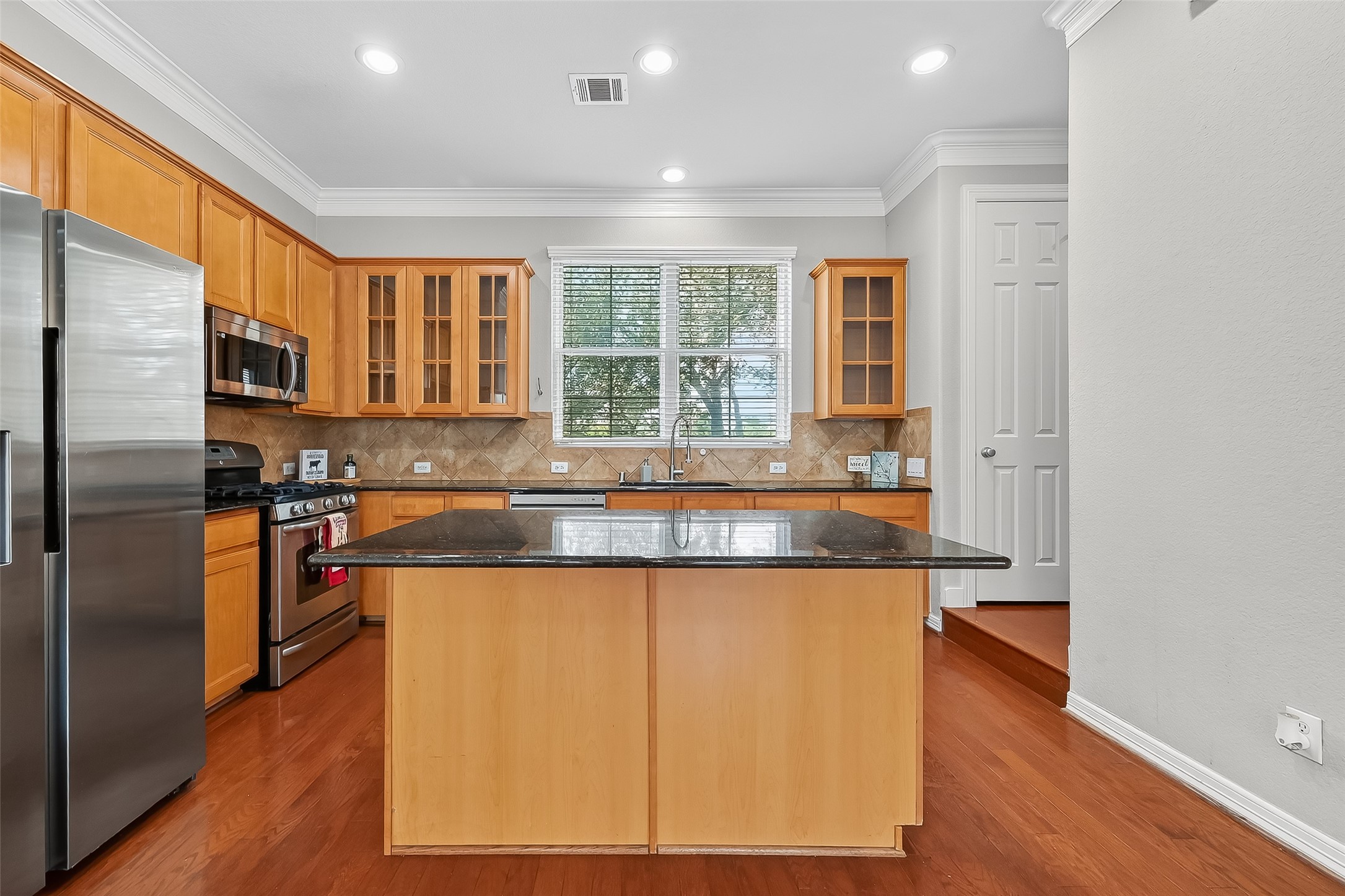 3019 Clearview Circle Houston, TX 77025 - Photo 14 of 42 a kitchen with stainless steel appliances granite countertop a refrigerator a sink dishwasher a stove with wooden cabinets and wooden floor