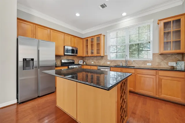 a kitchen with stainless steel appliances granite countertop a sink stove and refrigerator